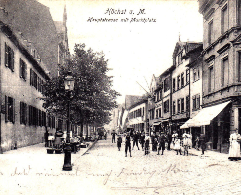 Zu sehen ist der alte Höchster Marktplatz um 1900 mit Marktständen vor dem Antoniterkloster in der ehemaligen Hauptstrasse, der heutigen Bolongarostraße in Frankfurt-Höchst. Historische Postkarte. Exemplar im Archiv des Vereins für Geschichte und Altertumskunde e.V. Frankfurt-Höchst.
