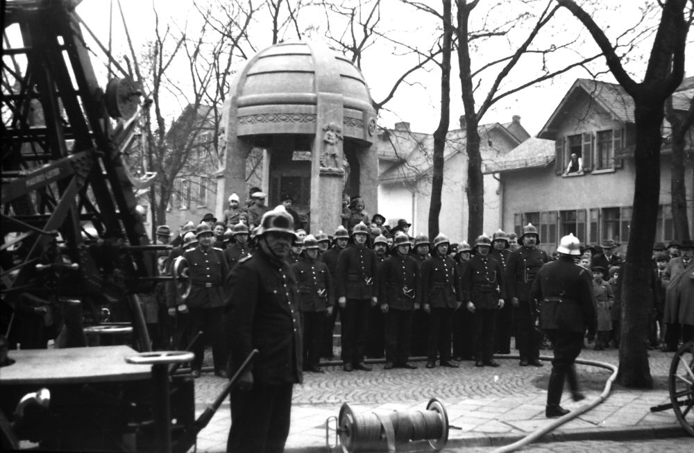 Die Höchster Feuerwehr übt einen Feuerwehreinsatz am Gebäude der Stadtsparkasse am Ettinghausenplatz. Im Hintergrund zu sehen der Brüningbrunnen, der vormals auf dem Höchster Schlossplatz stand.