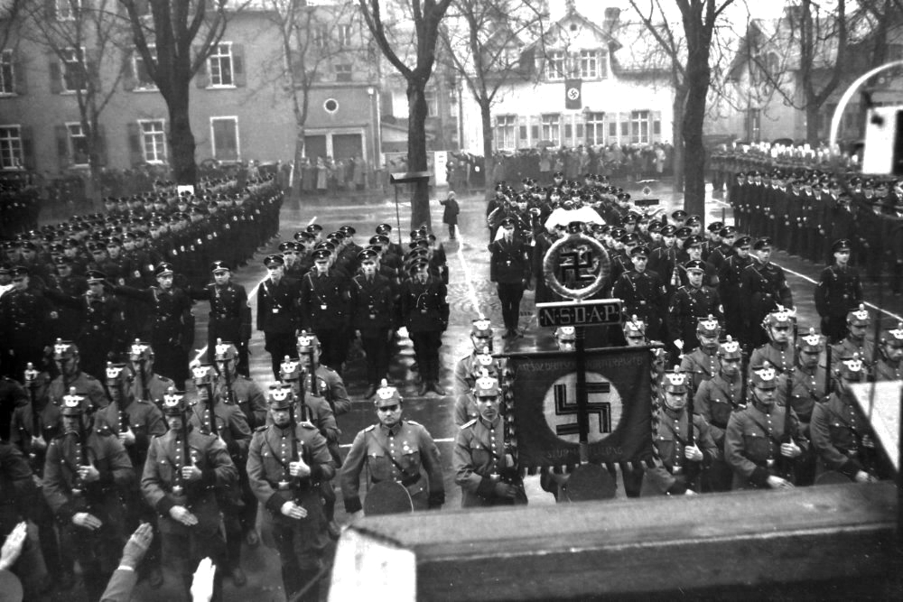 Aufmarsch der NSDAP um 1935 zu einer Kundgebung auf dem Höchster Marktplatz. Im Hintergrund sind Häuser der Melchiorstraße zu sehen. Der Blick von der Rednertribüne.